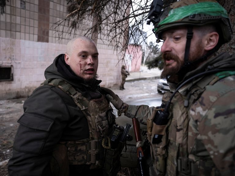 Ukrainian serviceman assists his injured brother-in-arms during medical evacuation from the frontline town of Druzhkivka