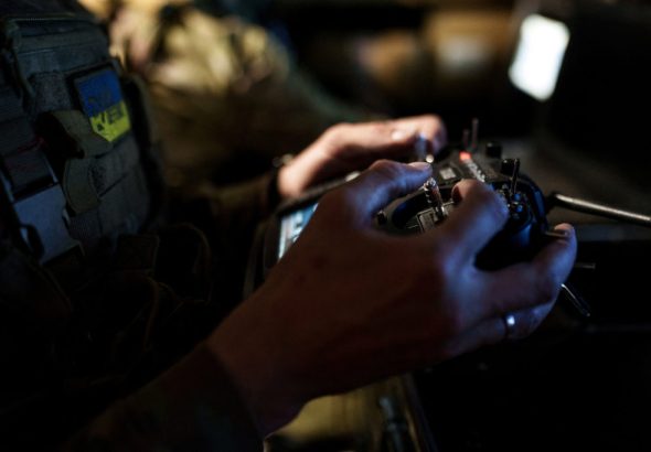 FILE PHOTO: Ukrainian serviceman controls a heavy combat drone while it flies over positions of Russian troops in Donetsk region